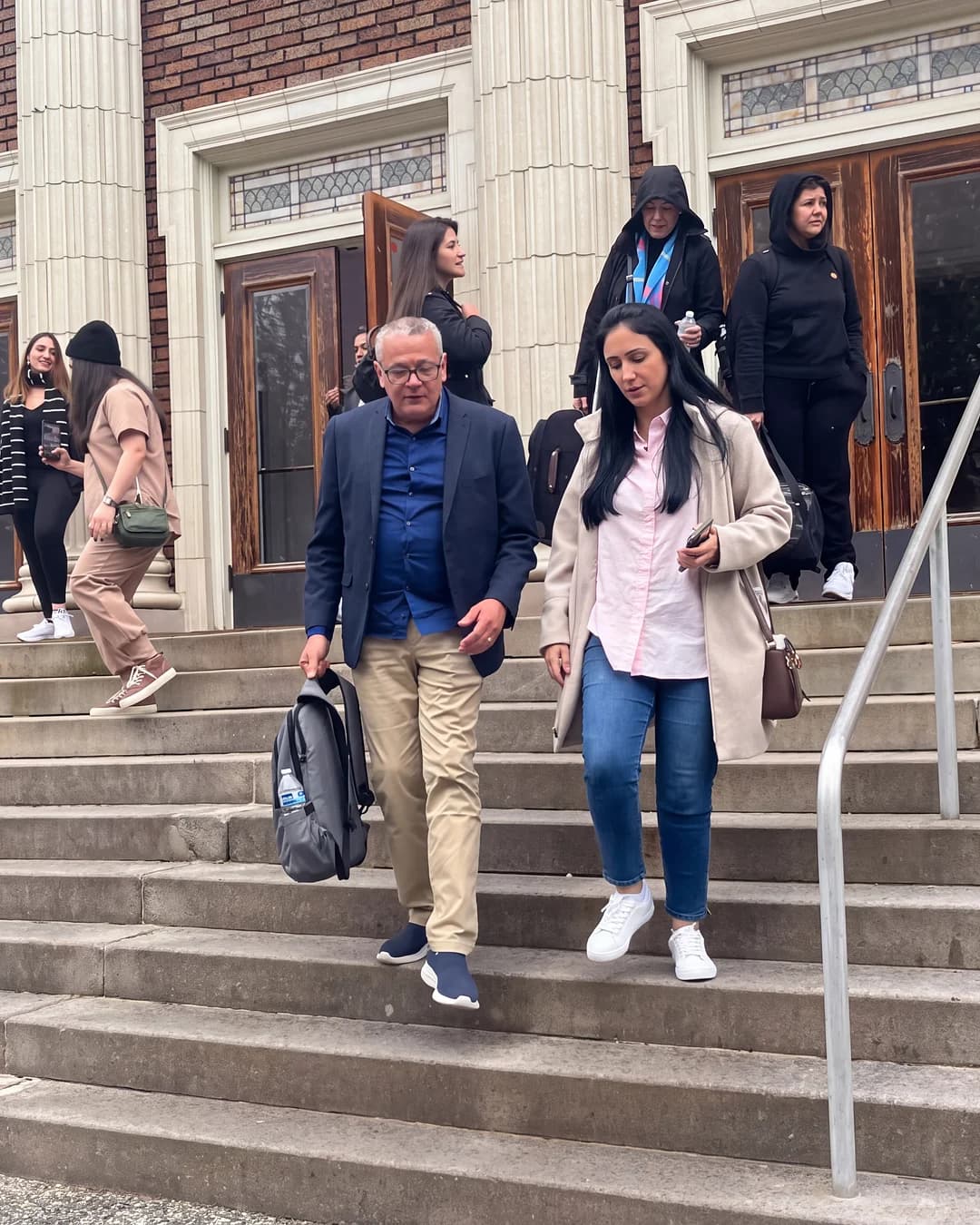 International students walking down the steps of a campus building after a school visit